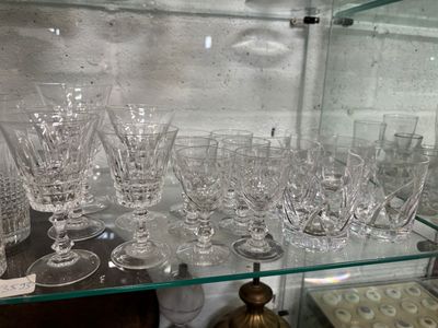 une étagère en verre sur laquelle sont posés de nombreux verres à vin