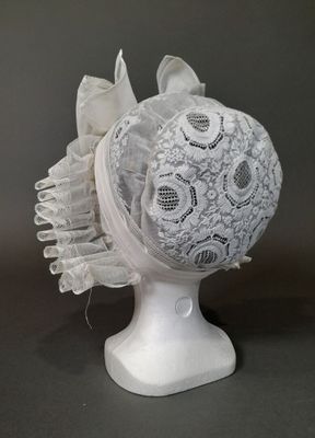 un chapeau blanc orné d'un motif en dentelle sur le dessus