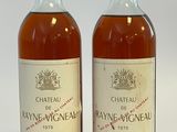 deux bouteilles de vin posées l'une à côté de l'autre sur une surface blanche