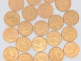 de nombreuses pièces d'or posées sur une surface blanche