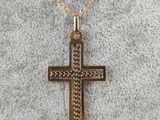 a gold cross pendant on a gold chain