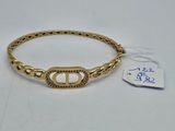 a close up of a gold bracelet with a tag on it