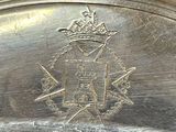 a close up of a silver plate with a crown on it