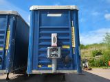 two blue portable toilets sitting side by side in a parking lot