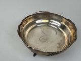 a small silver bowl with a handle on a table