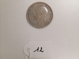 a close up of a coin on a white surface with a name tag