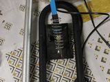 une photo représentant un aspirateur et un tuyau posés sur une table