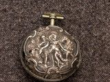 a silver pocket watch with a picture of a woman on it