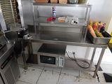 une petite cuisine équipée d'un micro-ondes et d'un plan de travail