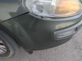 a close up of a car ' s headlight on the side of the road