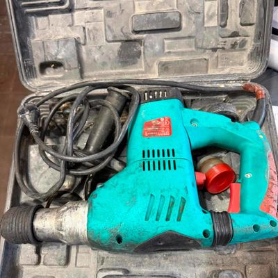 une perceuse électrique bleue rangée dans une mallette à outils