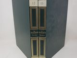 two books are stacked on top of each other on a white surface