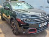 l'avant d'un SUV noir garé sur un parking à côté d'une camionnette blanche