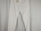a pair of white pants hanging on a hanger in front of a curtain