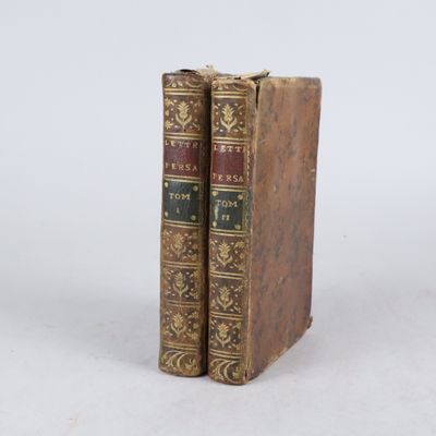 deux vieux livres posés l'un sur l'autre sur une surface blanche