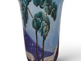 a blue vase with a painting of trees on it