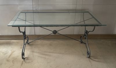 une table en verre avec un cadre en métal et un plateau en verre
