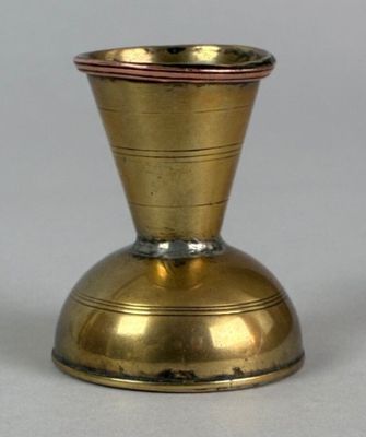 a small gold vase sitting on a white surface