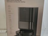 the box is open on a white table with a black coffee maker