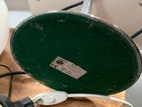 a green lamp that is on a wooden table