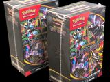 two boxes of pokemon trading cards are shown on a black background