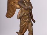 a statue of an angel holding a book on a table