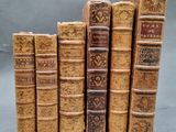 several old books stacked on top of each other on a table