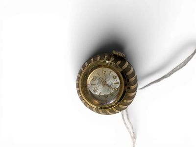 MORTIMA Petite montre boule. Pendentif en métal doré et guil…