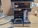 a coffee maker sitting on a table next to a cup