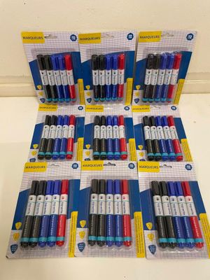 Six paquets de stylos assortis sont alignés sur une table