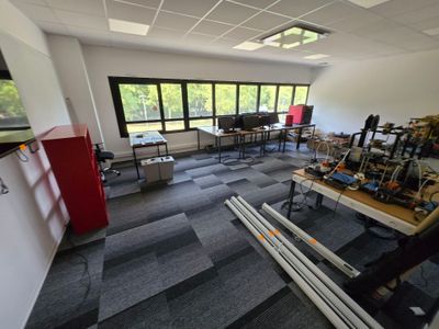 une salle où il y a beaucoup de bureaux et de chaises