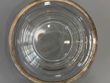 a glass bowl with a gold rim sitting on a table
