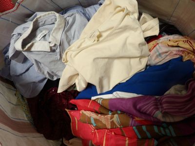un panier rempli de vêtements posé sur le sol
