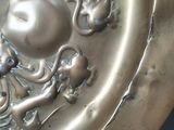 a metal plate with a face on it on a table