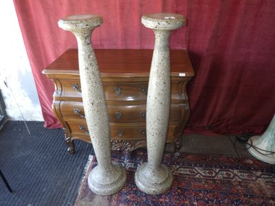 deux grands vases posés sur un tapis à côté d'une commode