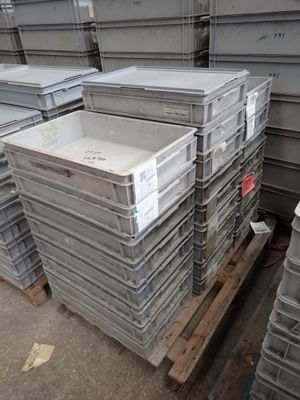 de nombreuses piles de récipients en plastique empilés sur une palette