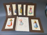 six cartes représentant des tenues féminines sont disposées en rang sur une table
