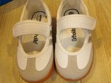 a pair of baby shoes on the floor next to a shoe box