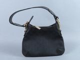 le petit sac à main noir est posé sur une surface blanche