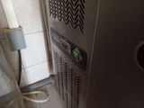 an image of a stainless steel water heater in the corner of a bathroom