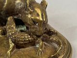 a close up of a bronze figurine of a mouse on a plate