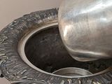 a silver vase that has a silver cup in it