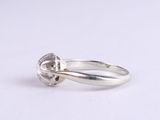 a close up of a diamond ring on a white surface