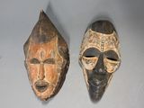 deux masques en bois posés sur une table