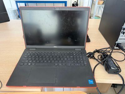 a laptop that is sitting on a desk with a charger