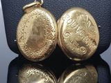 an image of a gold pocket watch on a black surface