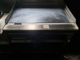 a large stainless steel grill in a dark room
