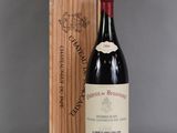 une bouteille de vin posée à côté d'une caisse en bois