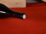a bottle of wine sitting on a red table cloth