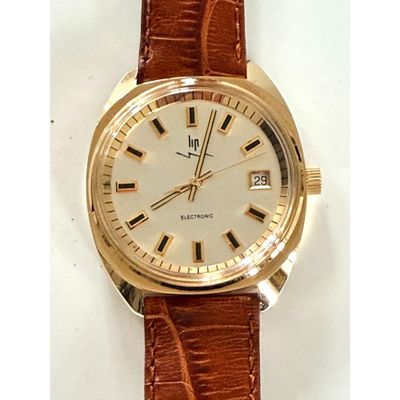une photo d'une montre en or avec un bracelet marron